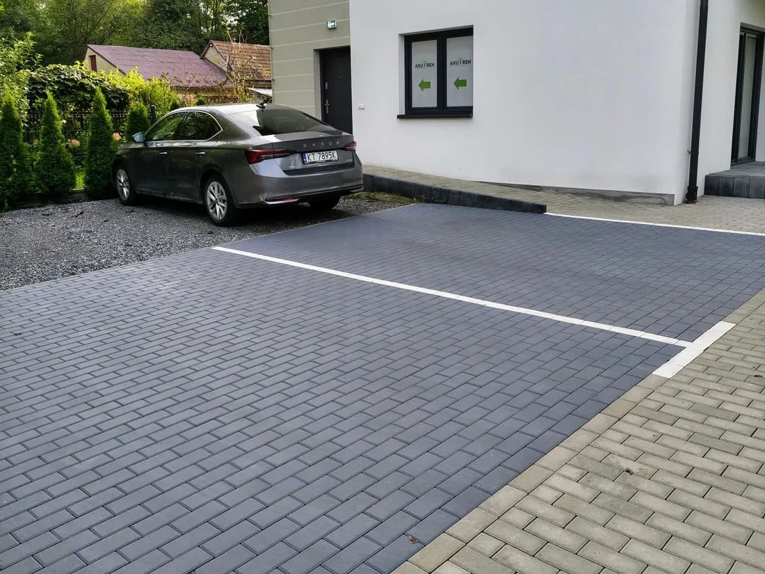 Dwa grafitowe miejsca parkingowe dla pacjentów przy budynku gabinetu AKU-REH w Brzesku